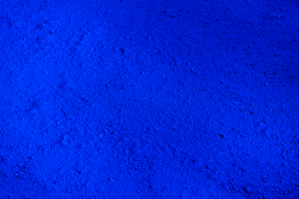Détail du pigment IKB® dans une table d’Yves Klein, révélant la matière vibrante de son bleu iconique.