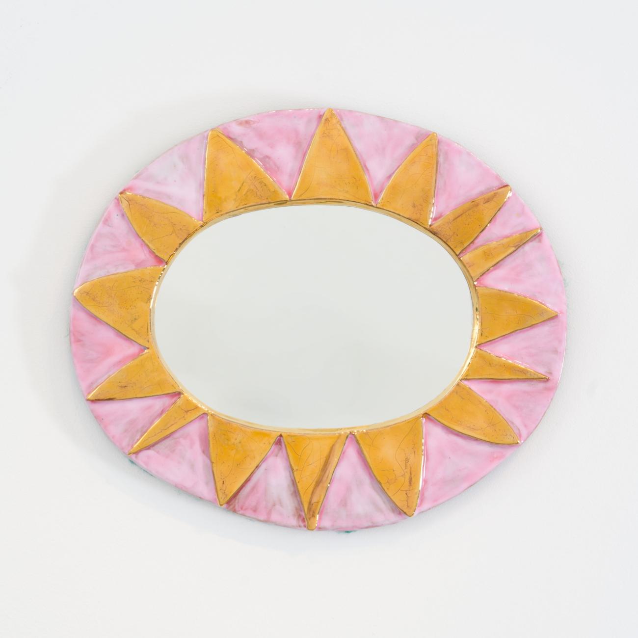 Miroir mural ovale en céramique émaillée rose et or, de Mithé Espelt. Motif rayonnant évoquant un soleil stylisé, intitulé Mexico, incarnant l’esthétique solaire et onirique de l’artiste.