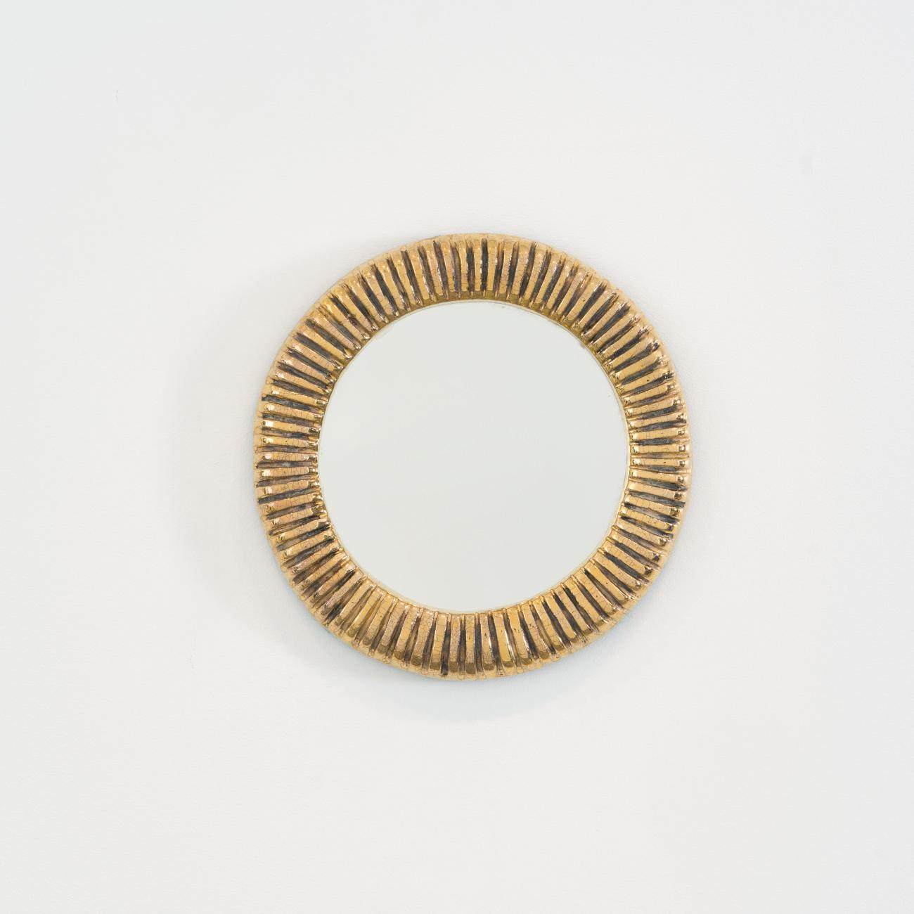 Miroir mural de Mithé Espelt, terre estampée et émaillée rehaussée d’or au four, modèle des années 1948–1950, de forme ronde.