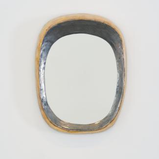 Grand miroir mural de forme libre par Mithé Espelt, vers 1948. Céramique estampée rehaussée de platine au four, contours irréguliers aux reflets dorés et argentés, exemplaire exceptionnel.
