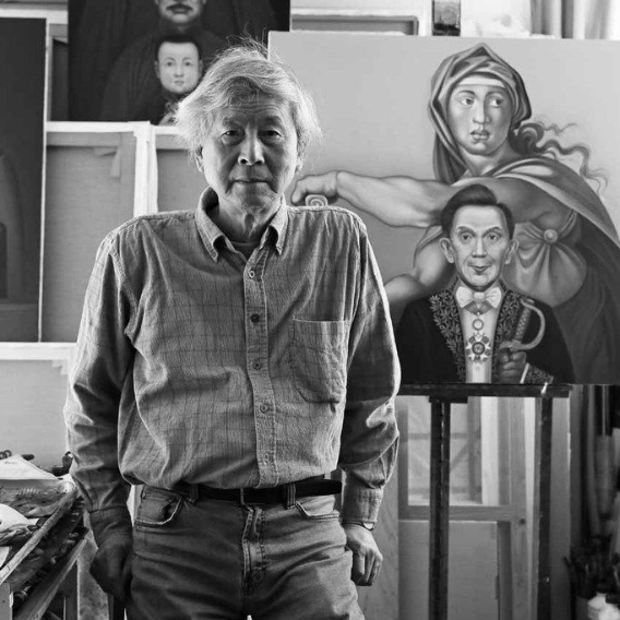 Portrait en noir et blanc de l'artiste dans son atelier, entouré de peintures figuratives